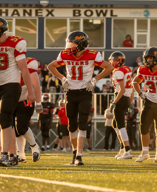 Rebels player number 11 standing on the field in evening light
